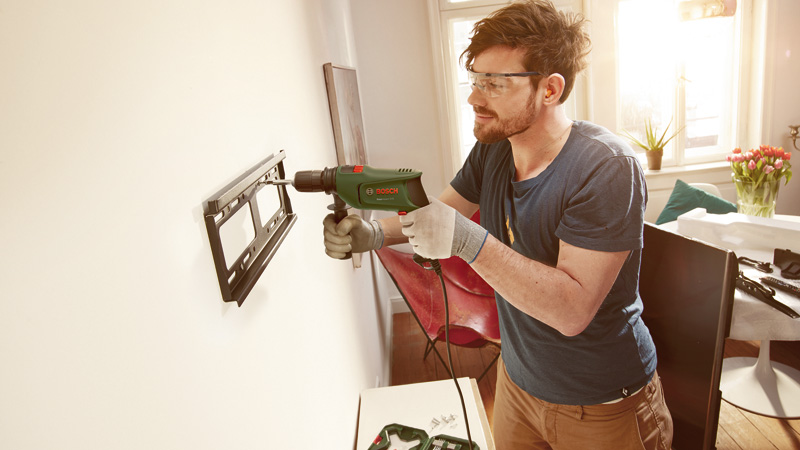 Anwendungsbild, Bohrmaschine, Wandmontage, Elektrowerkzeug, Gehäuse grün, Schraubarbeiten